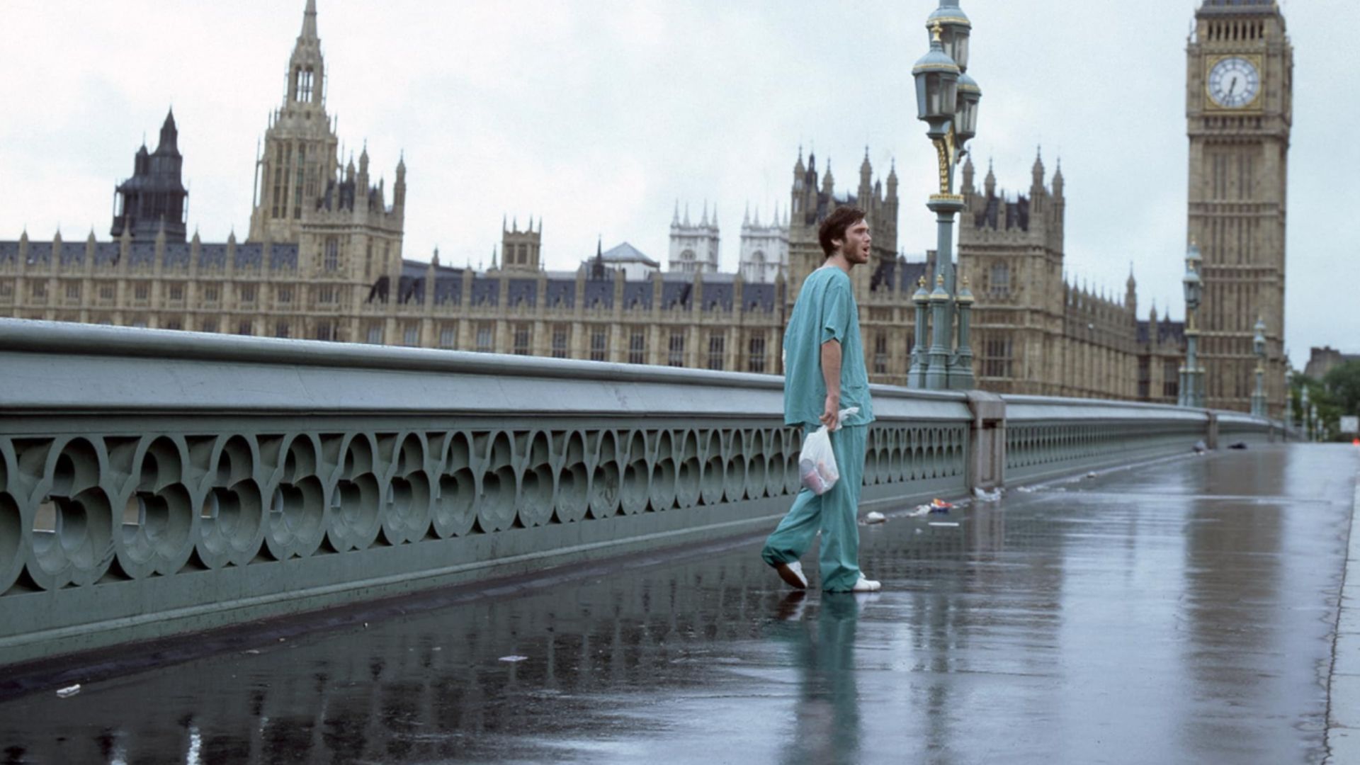 L'attore Cillian Murphy in abiti blu sta su un ponte vuoto con la torre dell'orologio Big Ben di Londra visibile nelle vicinanze