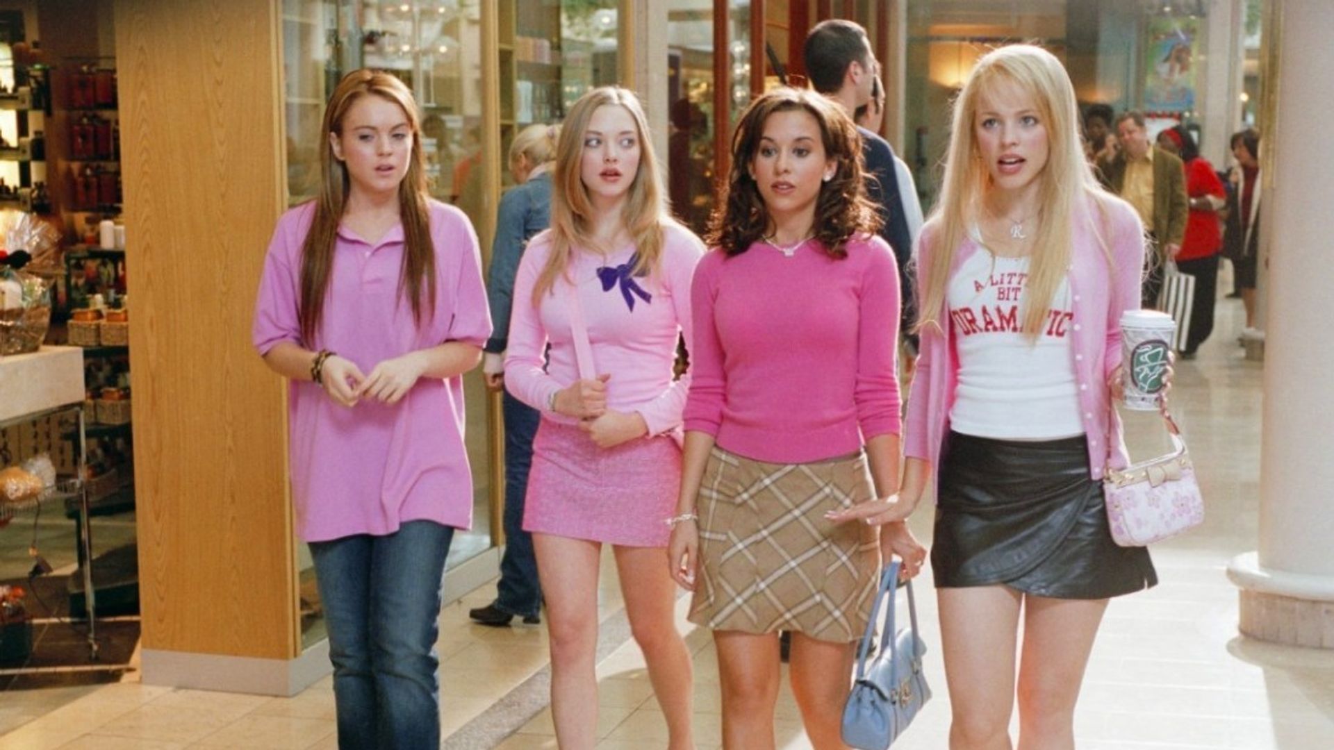 Quattro ragazze in abiti rosa camminano nel centro commerciale, distinguendosi per stile e sicurezza