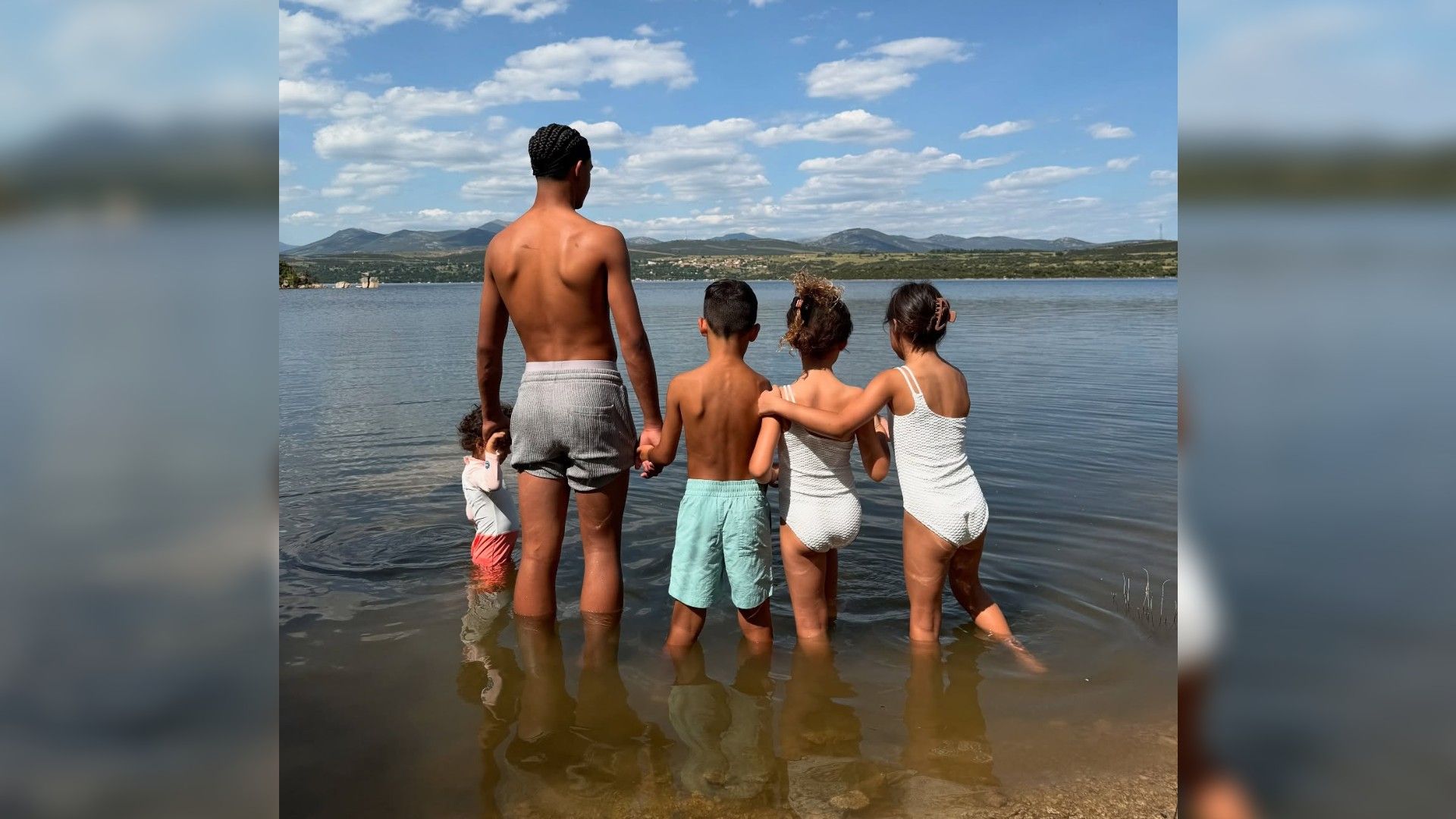 I cinque figli di Cristiano Ronaldo in piedi di spalle davanti alla fotocamera nell'acqua