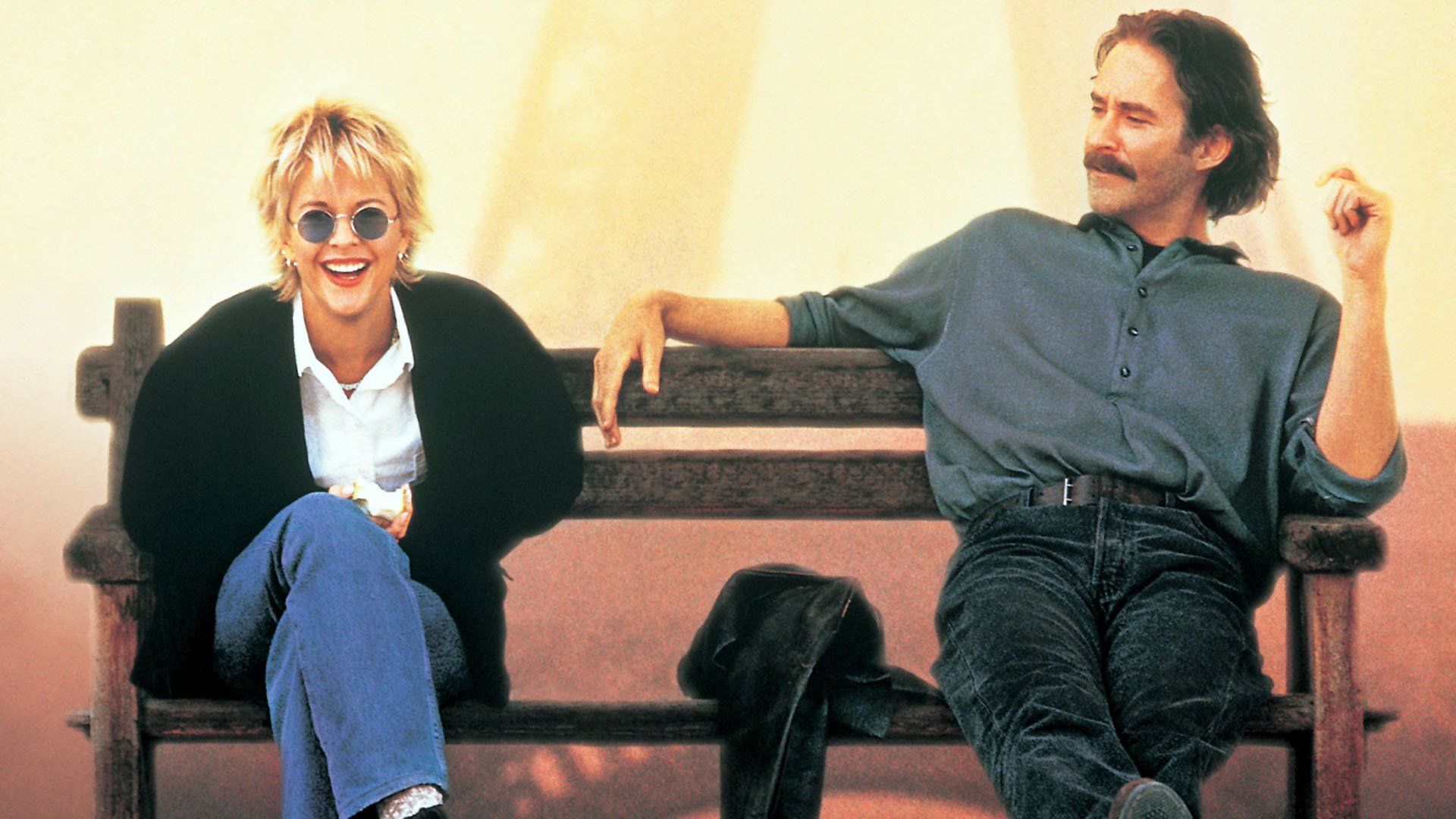 Meg Ryan e Kevin Kline seduti su una panchina, parlano e ridono