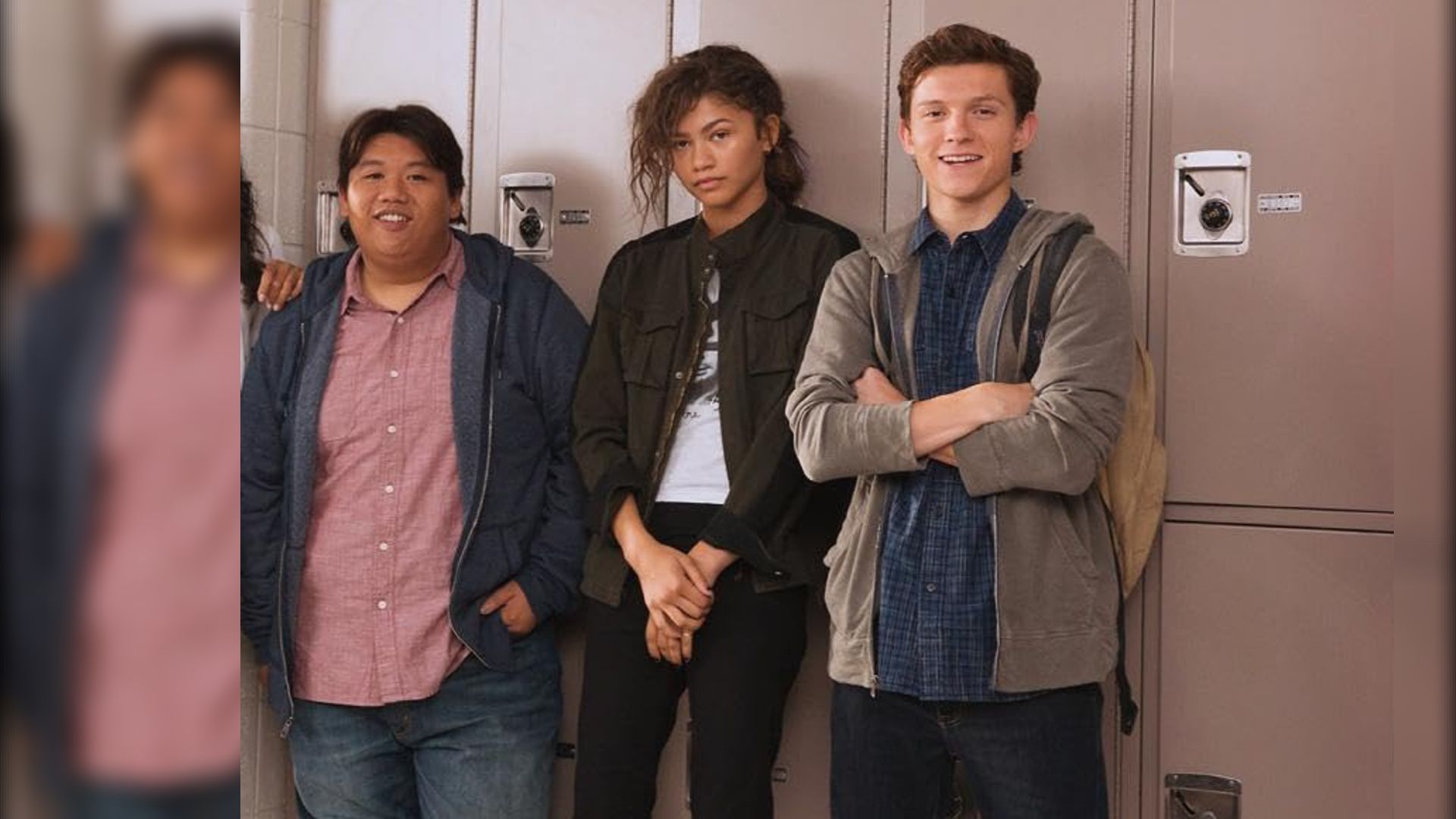 Gli attori Jacob Batalon, Zendaya e Tom Holland in abiti casual in piedi accanto agli armadietti della scuola