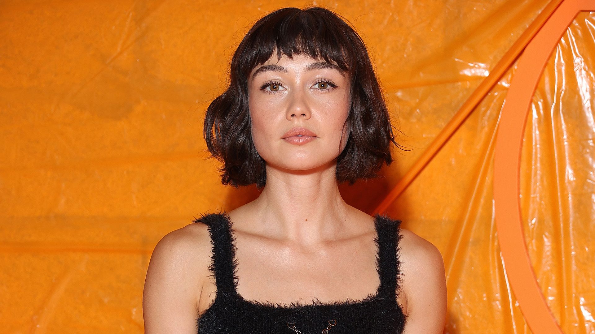 L'attrice Sydney Chandler su uno sfondo arancione
