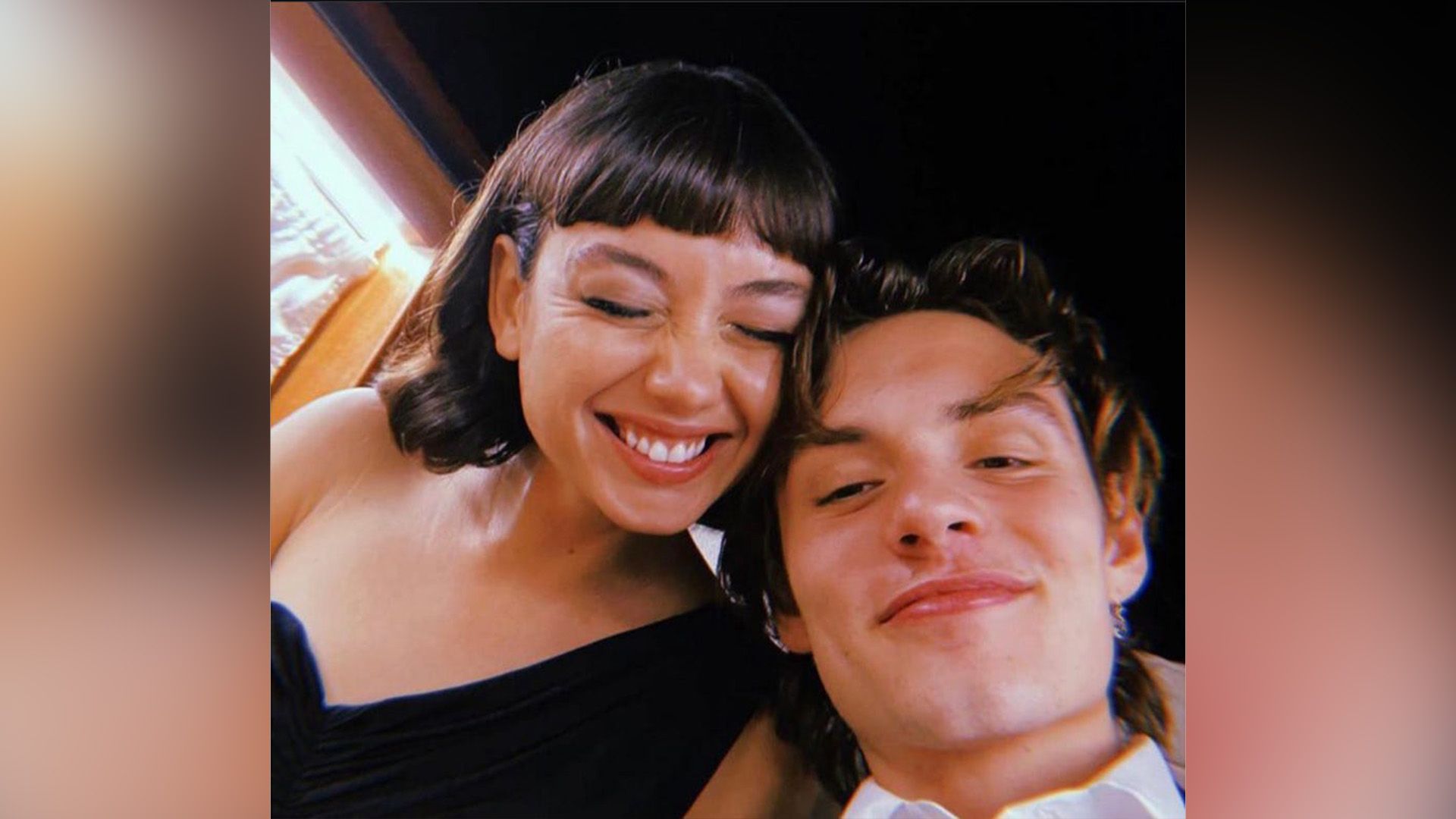 Sydney Chandler che ride e Louis Partridge sorridente