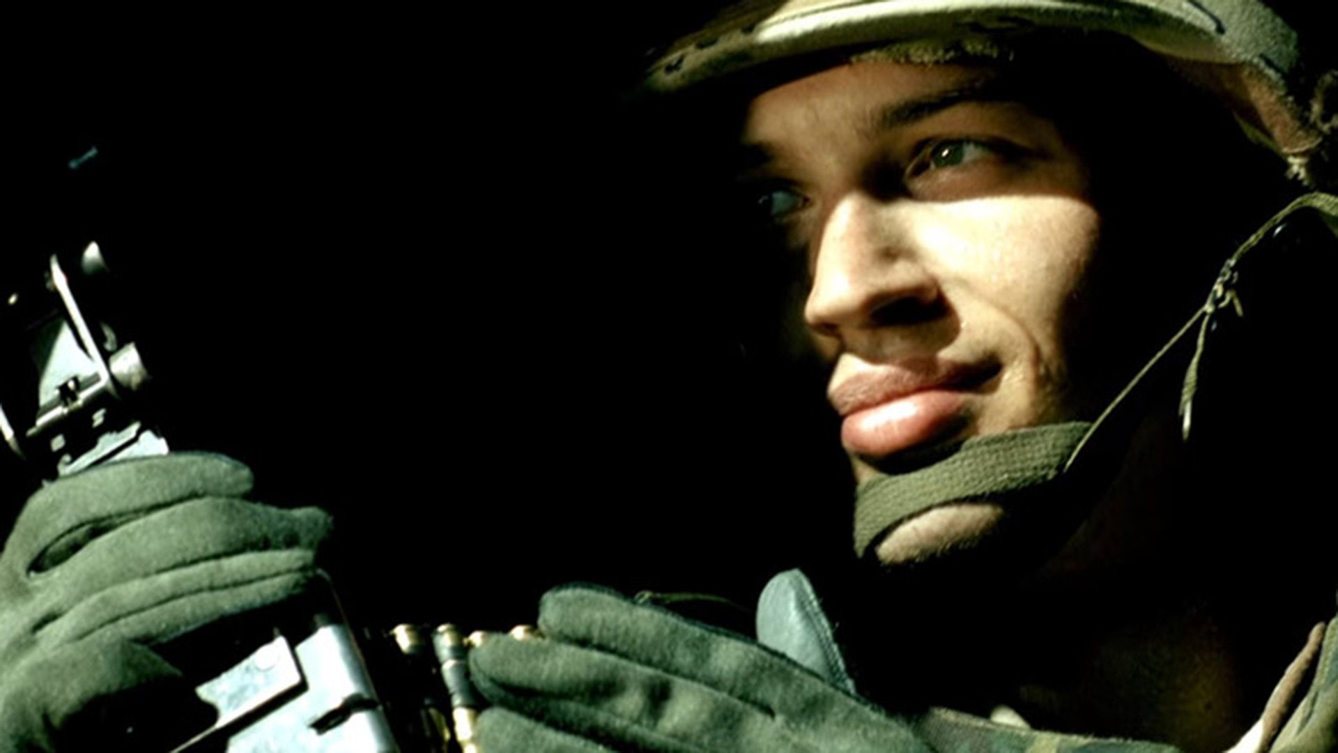 Tom Hardy in uniforme militare e casco, viso mezzo nascosto nell'ombra