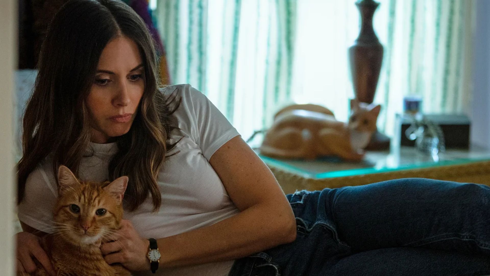 Alison Brie giace su un letto con un gatto tra le braccia