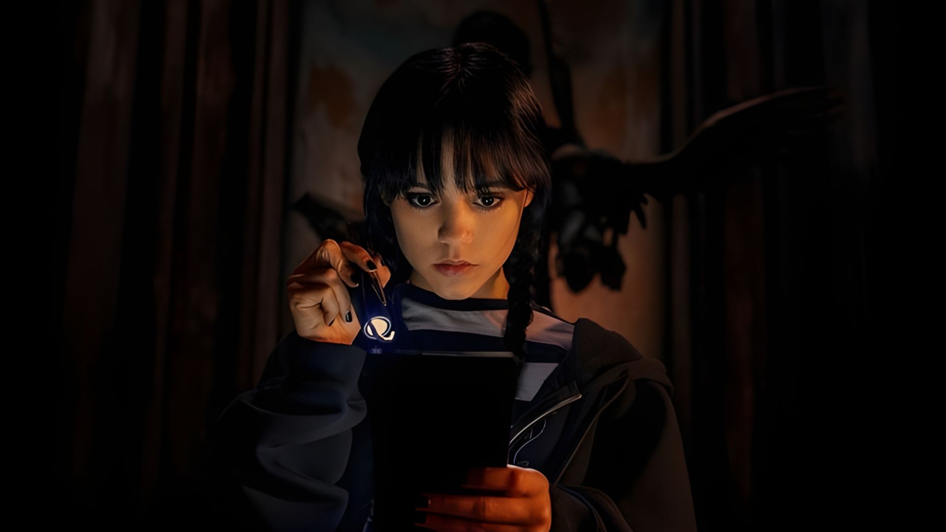 Jenna Ortega nei panni di Wednesday Addams che tiene una torcia e guarda un libro