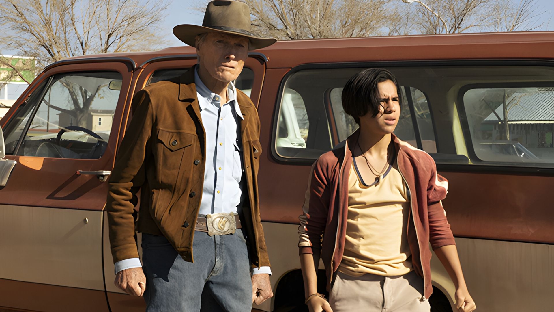 Clint Eastwood ed Eduardo Minett in piedi accanto a un pickup truck su uno sfondo di strada soleggiata