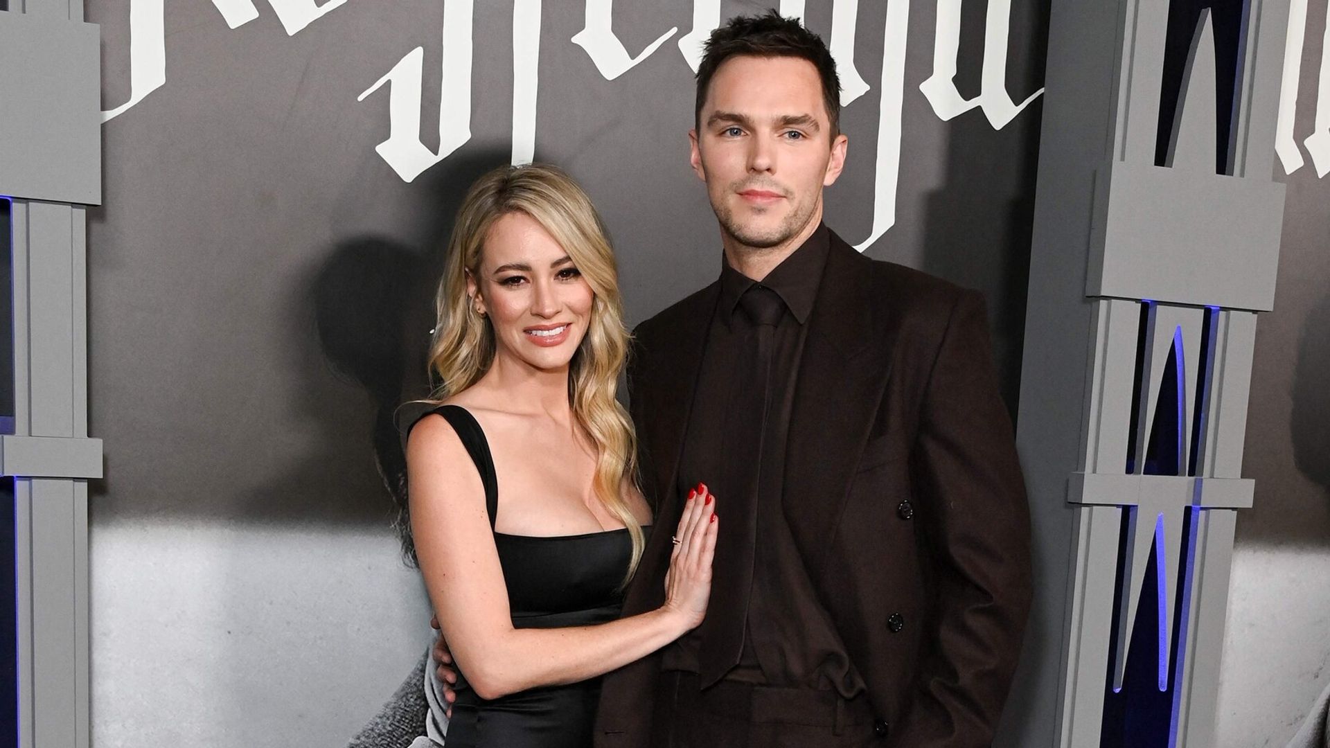 Nicholas Hoult in abito scuro e Bryana Holly in vestito nero posano insieme sul red carpet