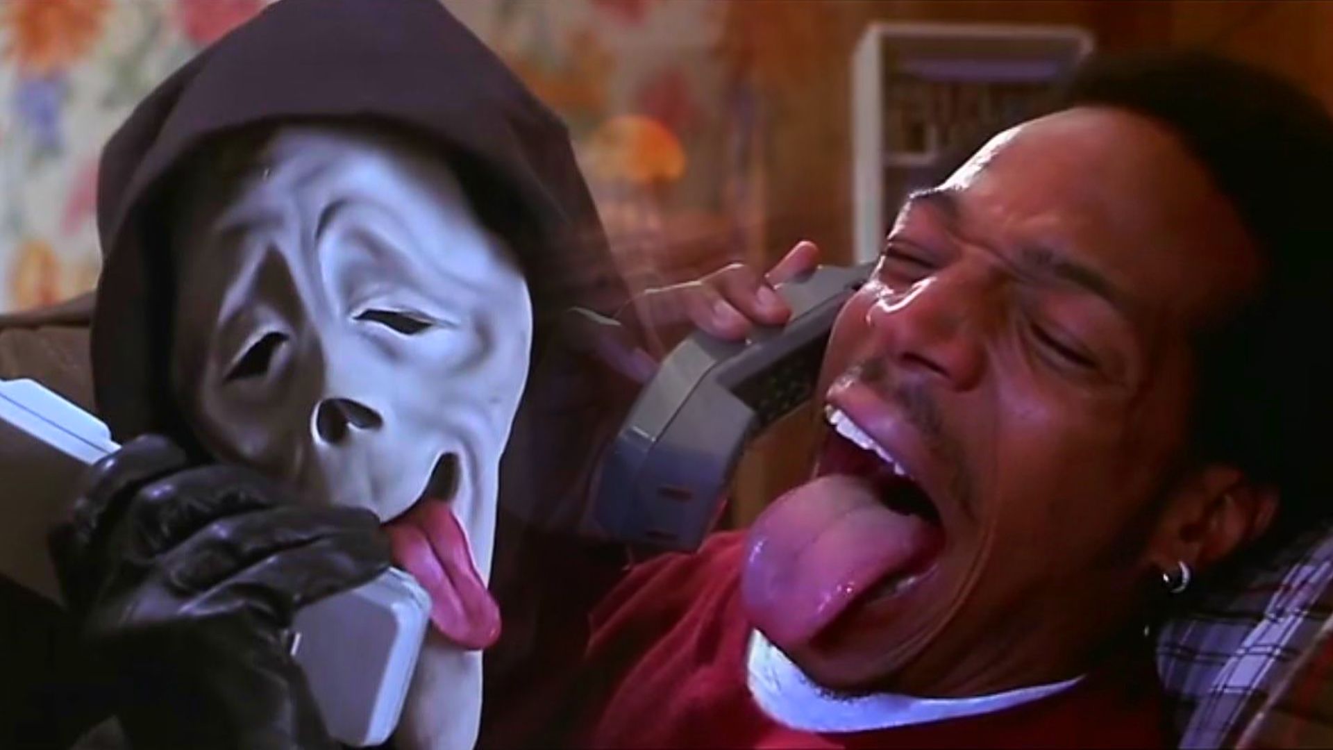 Un uomo con una maschera bianca e un uomo in maglione rosso che parlano al telefono sorridendo
