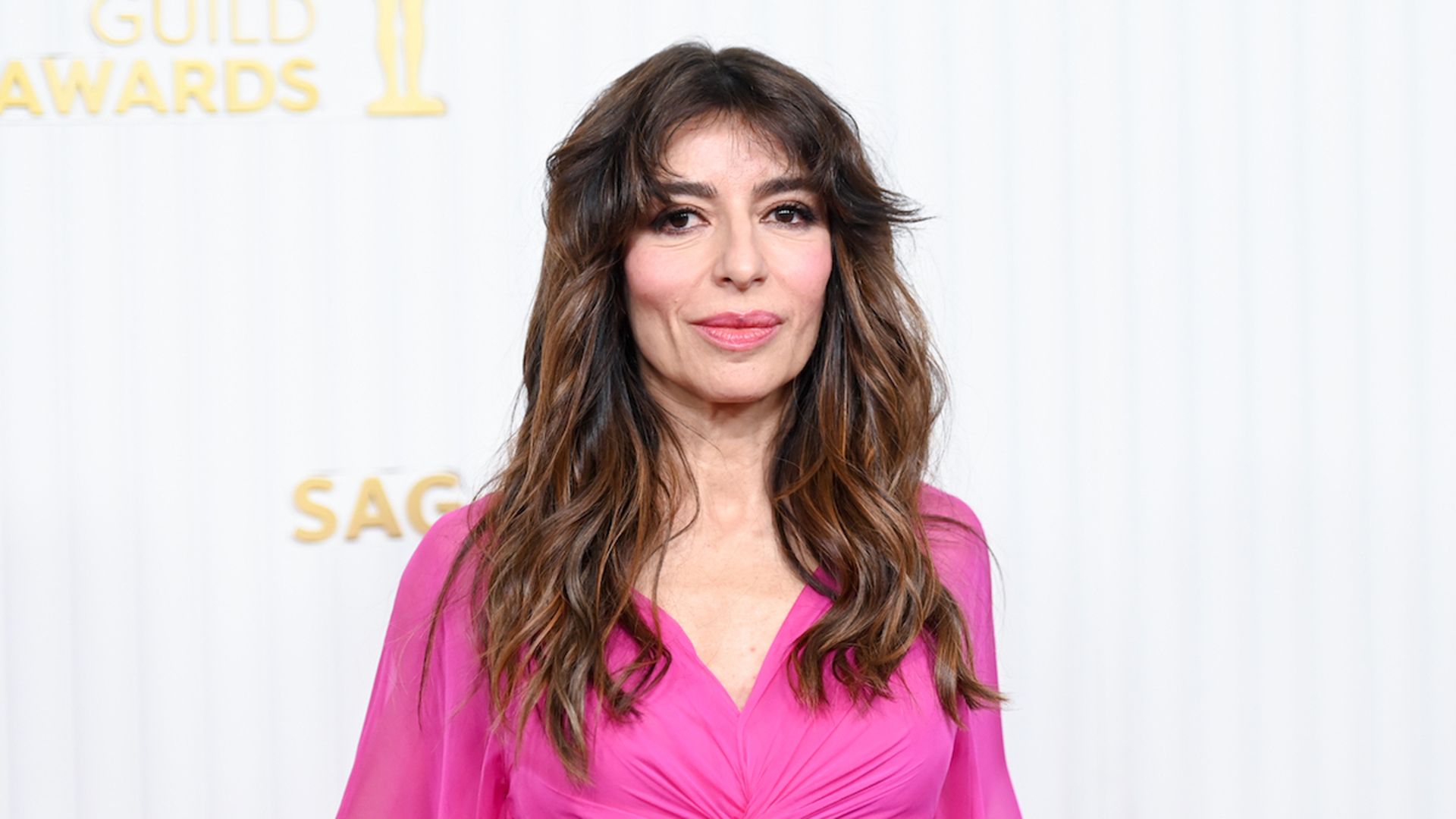 Sabrina Impacciatore in un vestito rosa su sfondo bianco