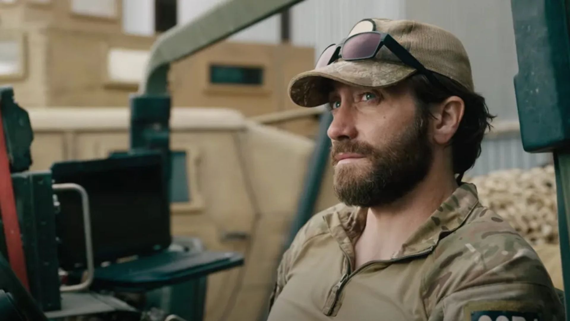 Jake Gyllenhaal in uniforme militare e berretto con occhiali sulla visiera seduto che guarda di lato con espressione seria