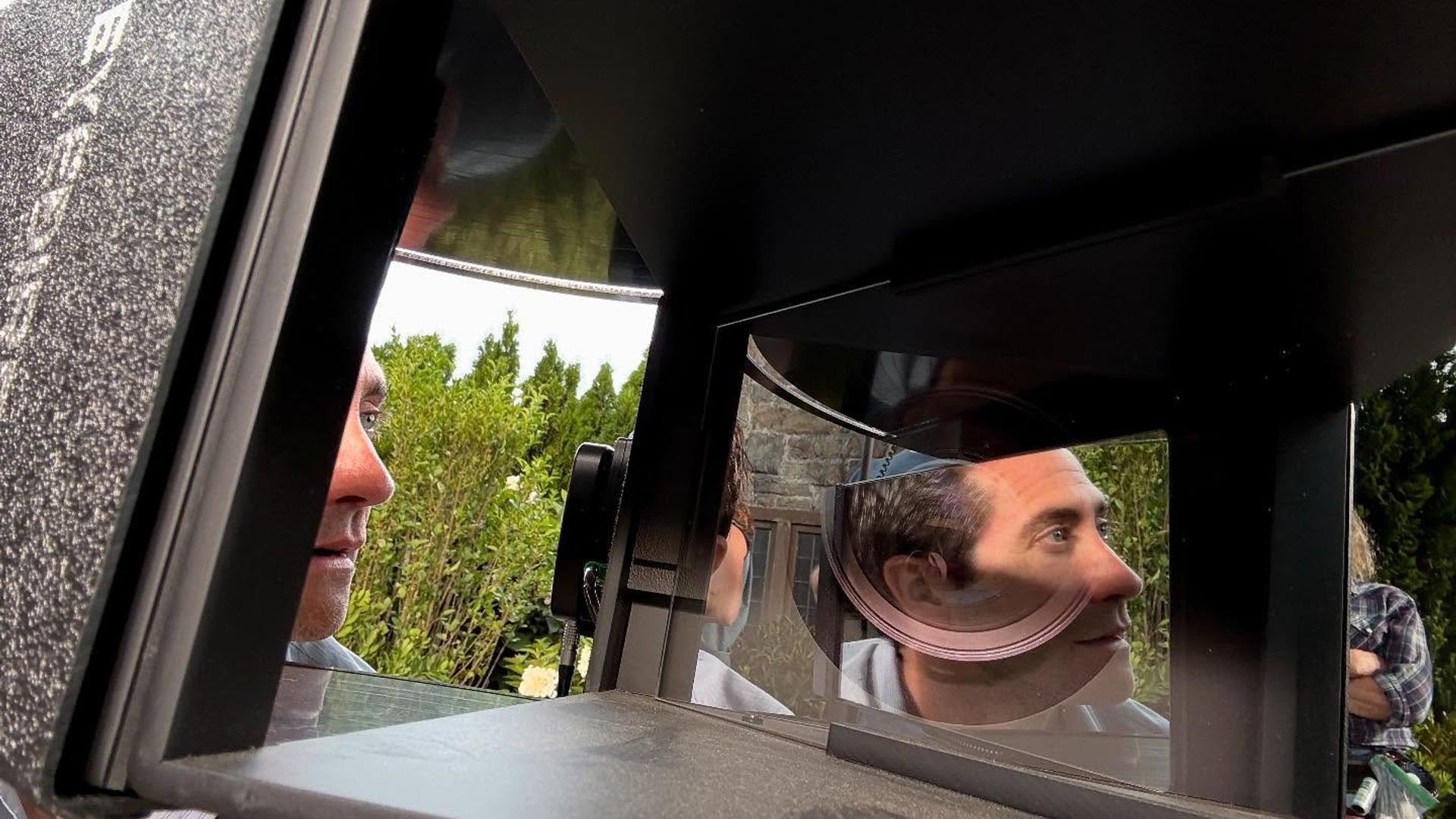 Jake Gyllenhaal guarda in un'attrezzatura con specchi e lenti, il suo volto si riflette nelle superfici ottiche