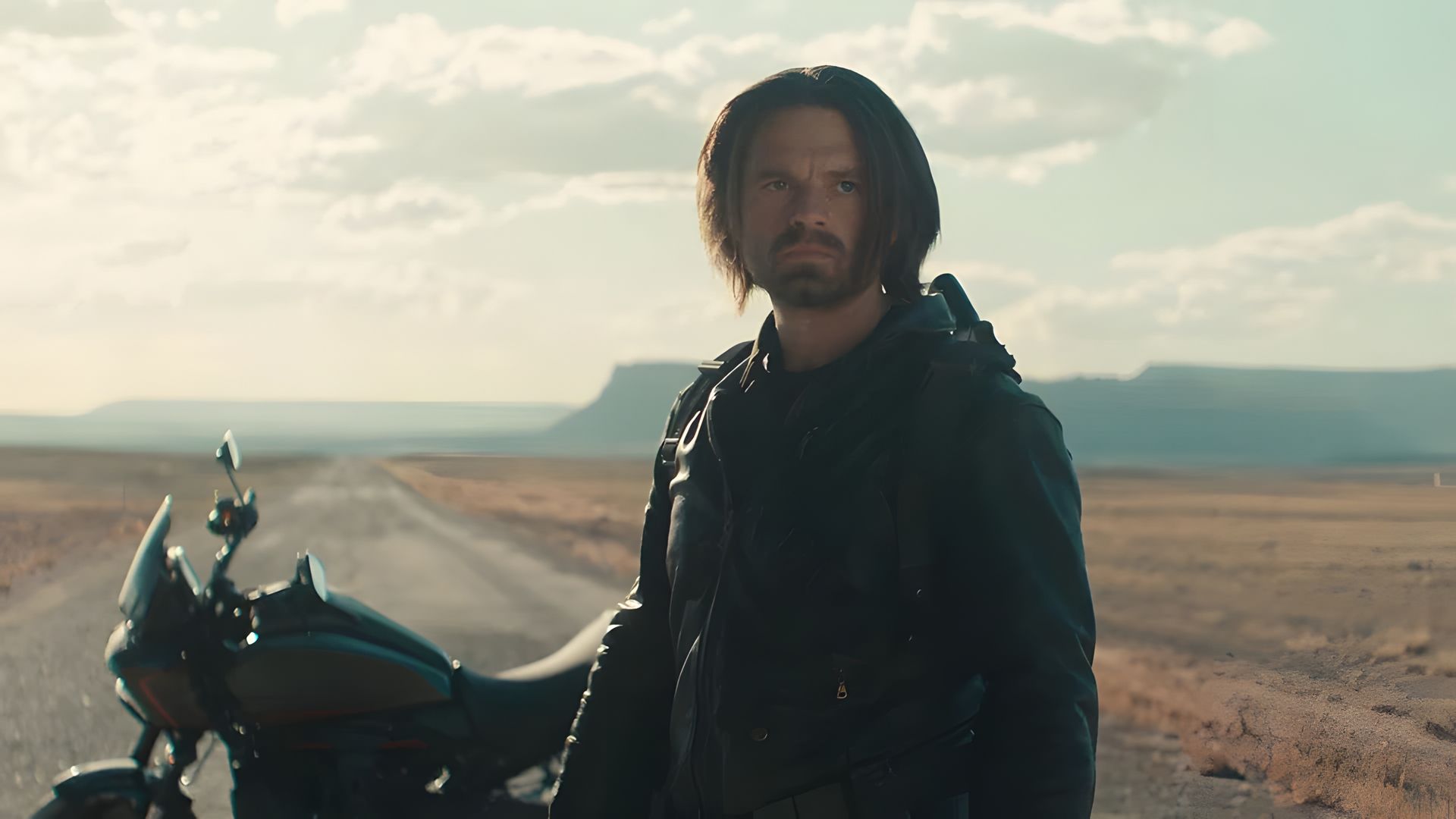 Sebastian Stan nei panni del Winter Soldier sullo sfondo di una moto e una strada