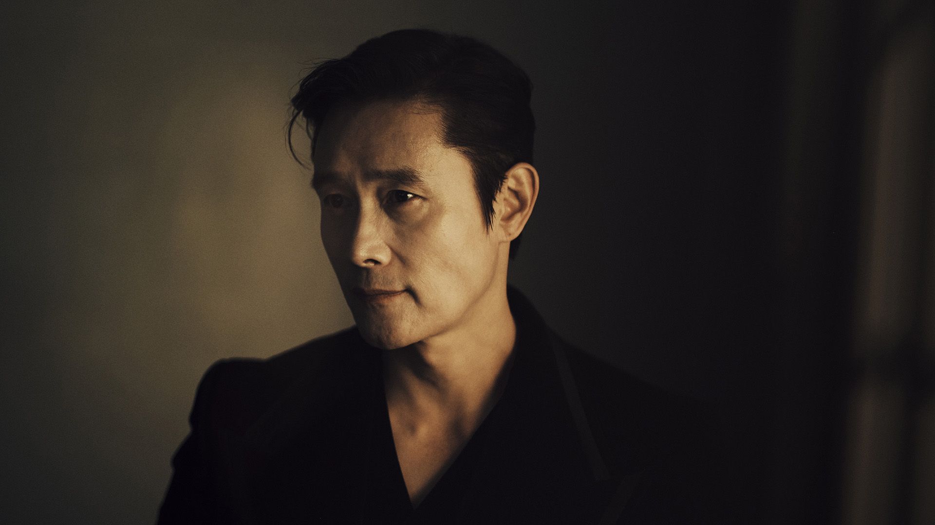 L'attore Lee Byung-hun di profilo in una luce soffusa