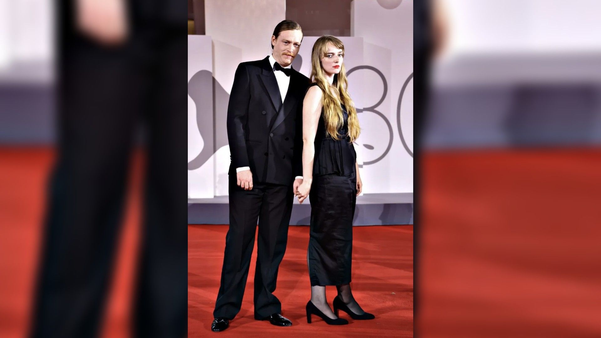 Caleb Landry Jones e Katya Zvereva in abiti da sera posano sul red carpet tenendosi per mano