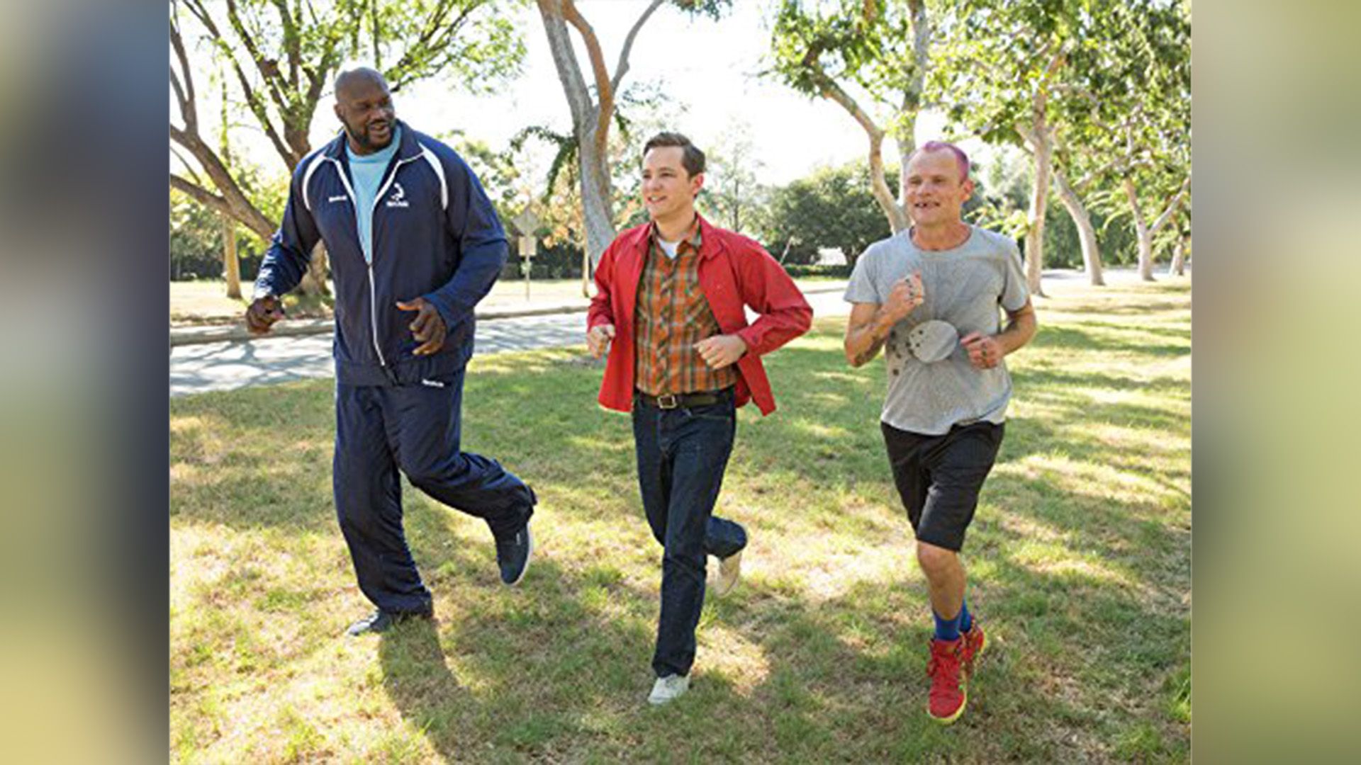 Shaquille O'Neal, Lewis Pullman e Flea che corrono su un prato verde