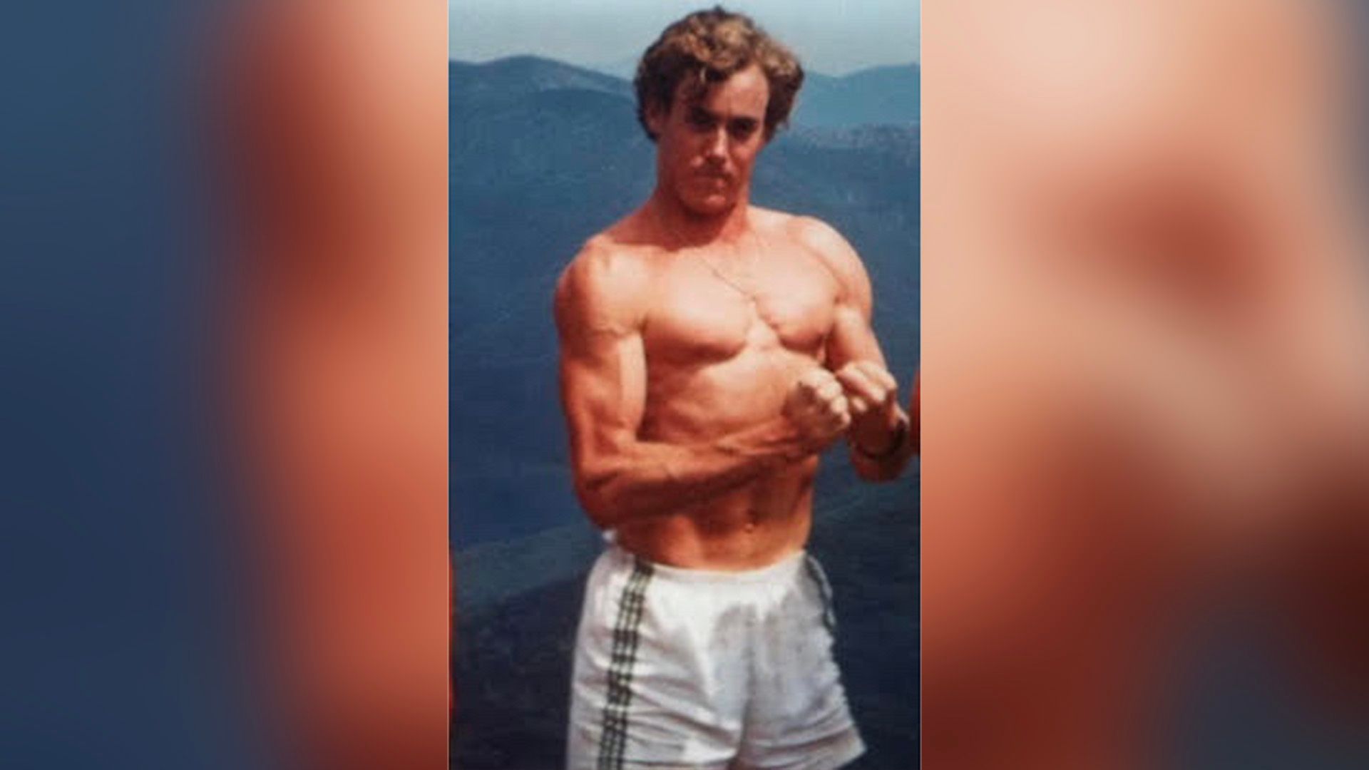 Il giovane John C. McGinley in pantaloncini mentre mostra i suoi muscoli