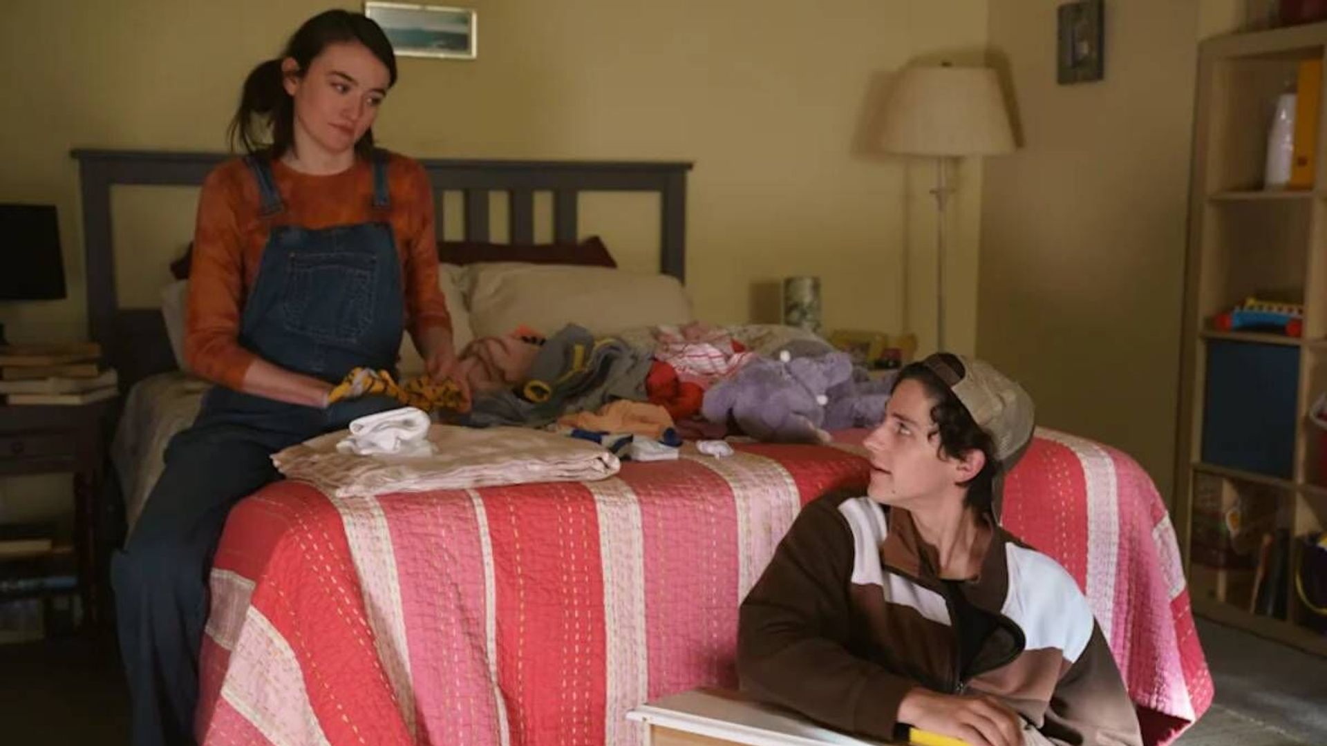 Sarah Pidgeon e Owen Painter seduti su un letto, una scena dalla serie "The Sex Lives of College Girls"